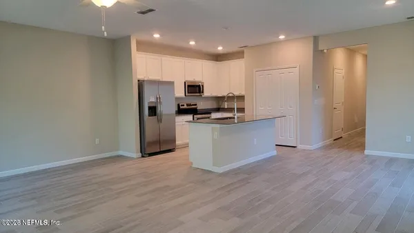 a kitchen with stainless steel appliances a refrigerator and a stove top oven