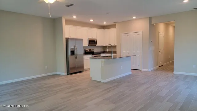 a kitchen with stainless steel appliances a refrigerator and a stove top oven