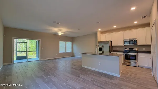 a kitchen with stainless steel appliances granite countertop a stove top oven a sink and a microwave