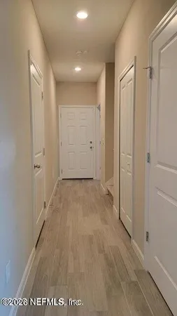 a view of a hallway with wooden floor