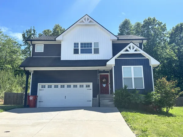 a view of a house with a yard and garage