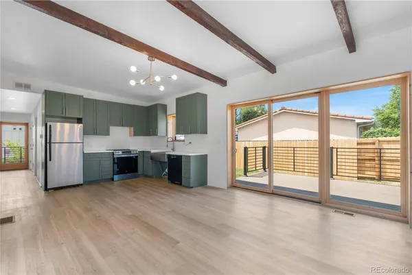 a large white kitchen with stainless steel appliances kitchen island granite countertop a sink and cabinets with wooden floor