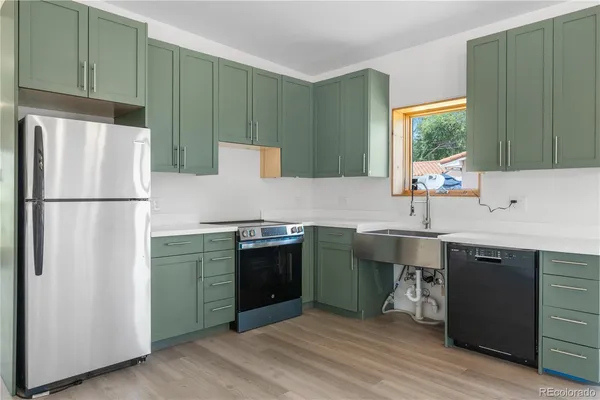 a kitchen with kitchen island a sink stainless steel appliances and cabinets