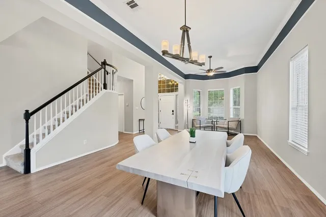 a view of a dining room and livingroom with furniture wooden floor a chandelier