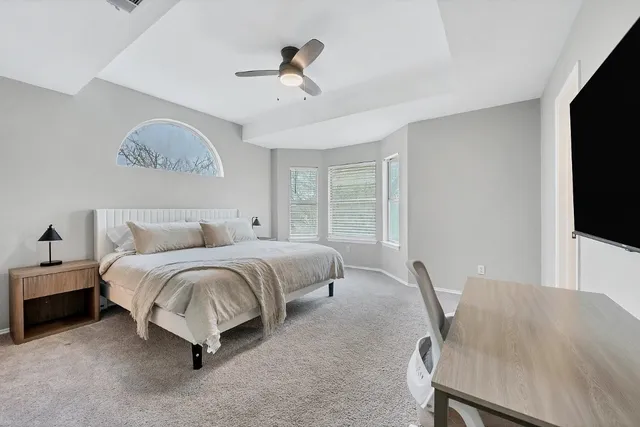 a spacious bedroom with a bed a desk and chair