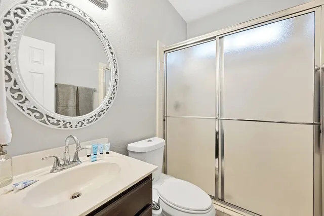 a bathroom with a sink mirror vanity and toilet