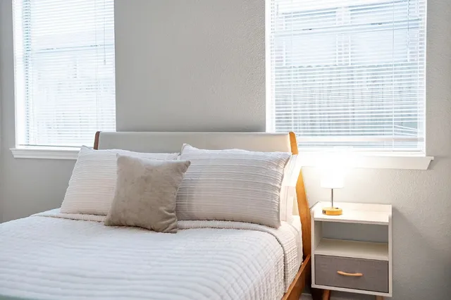 a large bed sitting in a bedroom next to a window