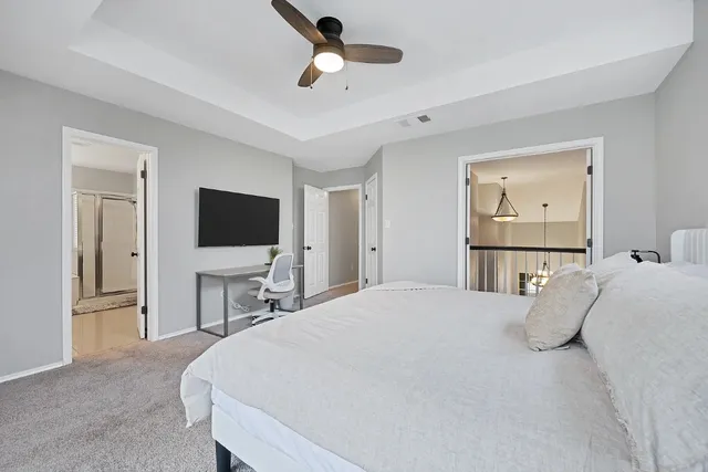 a bedroom with a bed tv and a chandelier