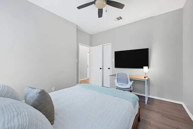 a bedroom with a bed tv and chair