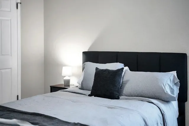 a large bed in a bedroom next to a window