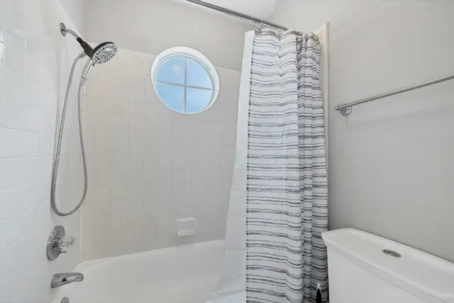 a bathroom with a shower curtain and a shower