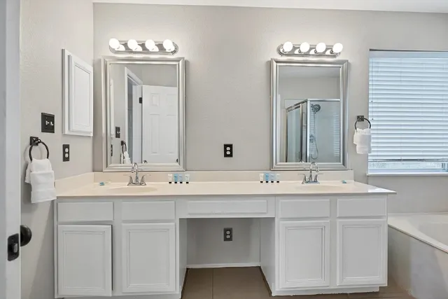 a bathroom with double vanity sinks and a mirror