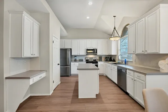 a kitchen with white cabinets and stainless steel appliances