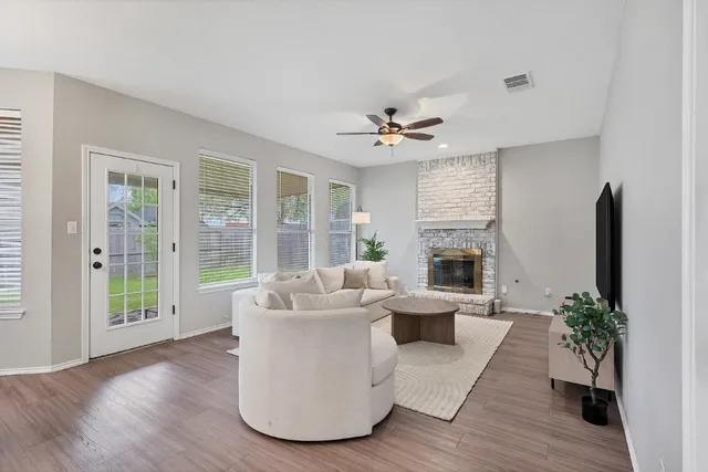 a living room with furniture fireplace and a large window