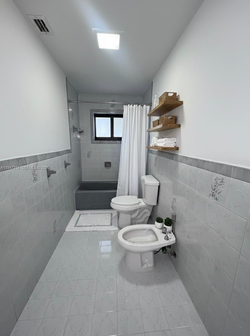 6875 Southwest 148th Court Miami, FL 33193 - Photo 11 of 16 a white toilet sitting next to a bathroom sink and tub