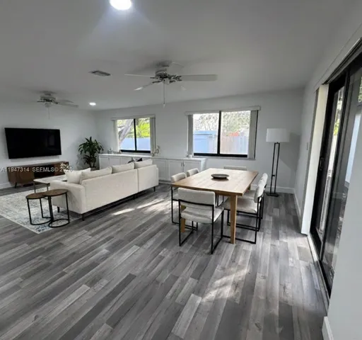 a living room with furniture and a flat screen tv with wooden floor