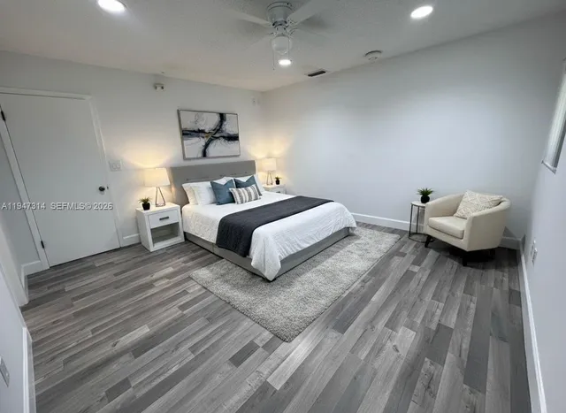 a bedroom with a bed and a wooden floor