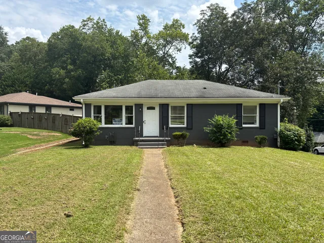 a front view of a house with yard and green space