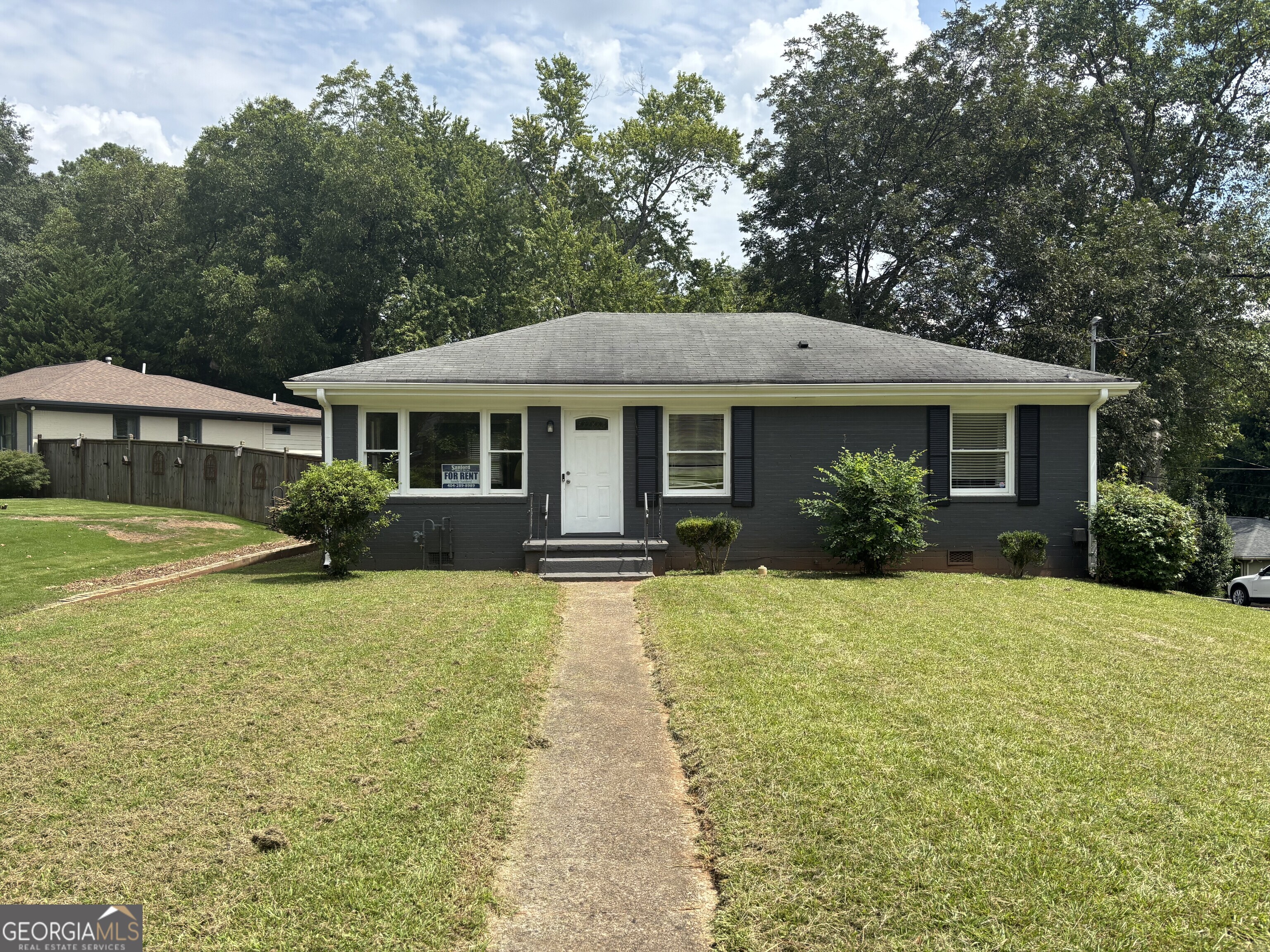 a front view of a house with yard and green space