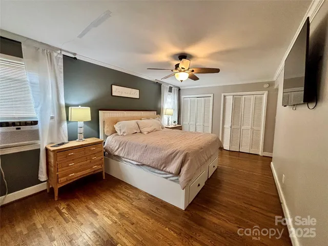 a spacious bedroom with a bed and a flat screen tv