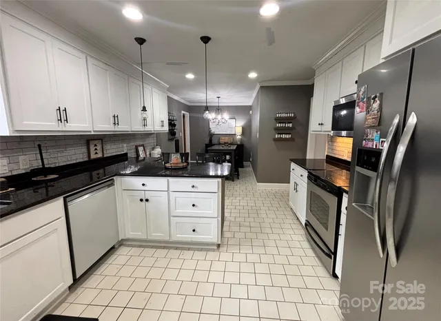 a kitchen with stainless steel appliances granite countertop a refrigerator and a sink
