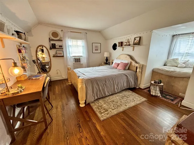 a bedroom with a bed a mirror and desk