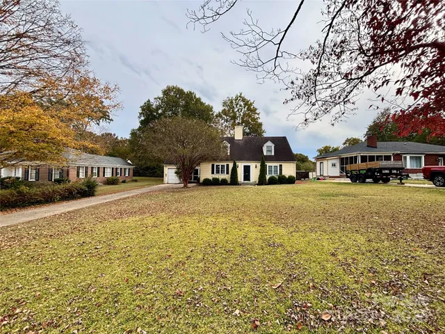 a front view of a building with large trees