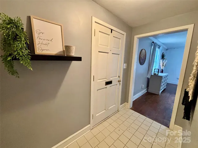 a view of a hallway to a bedroom with wooden floor and closet