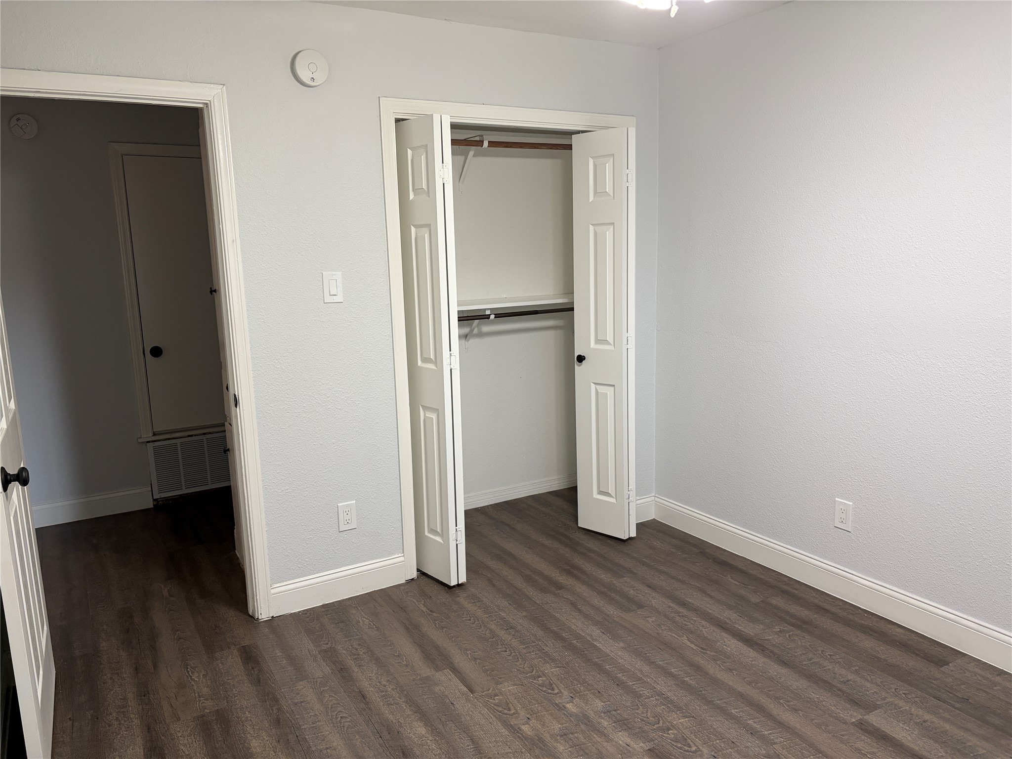 3109 Plantation Road, Unit B Austin, TX 78745 - Photo 6 of 8 an empty room with wooden floor and a hallway
