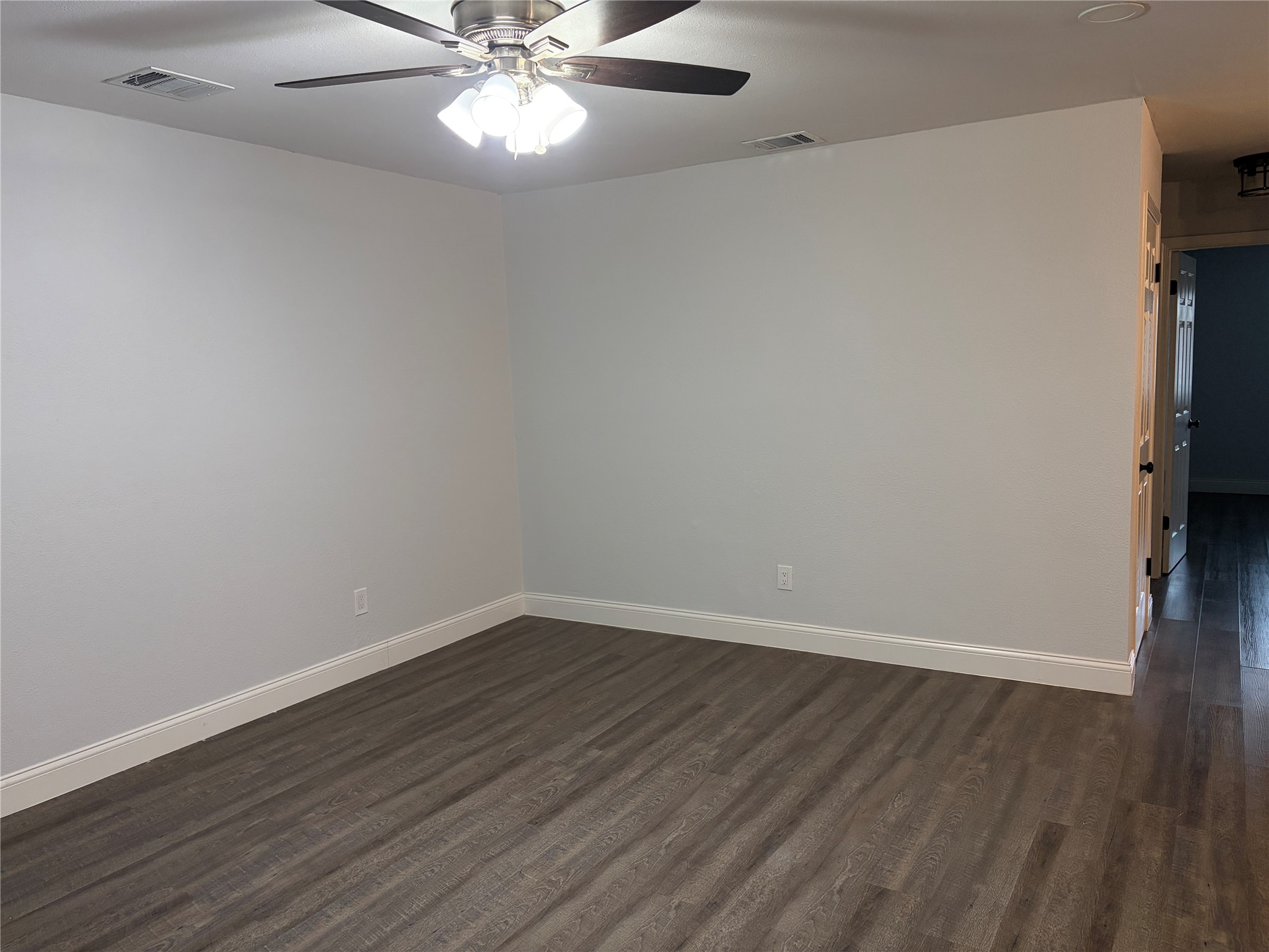 3109 Plantation Road, Unit B Austin, TX 78745 - Photo 7 of 8 a view of an empty room with wooden floor and a ceiling fan