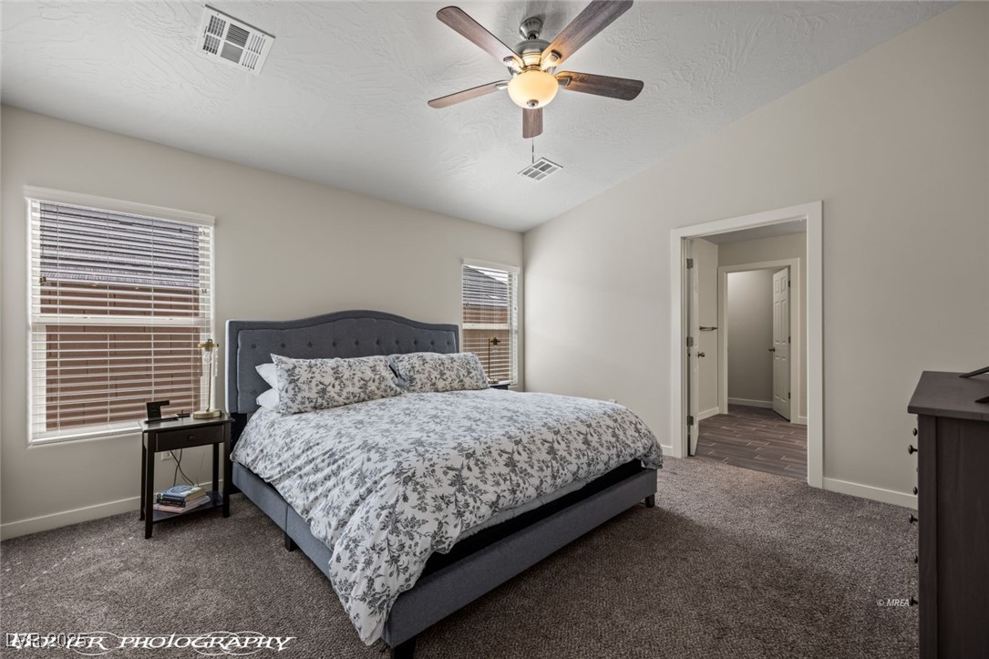 942 Shadow Hawk Ridge Mesquite, NV 89027 - Photo 37 of 67 Carpeted bedroom featuring baseboards, lofted ceiling, a ceiling fan, and a textured ceiling