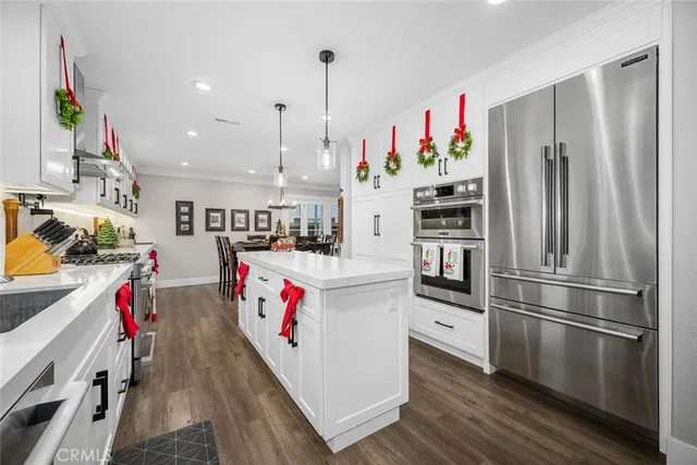 a very nice looking kitchen with wooden floor and stainless steel appliances