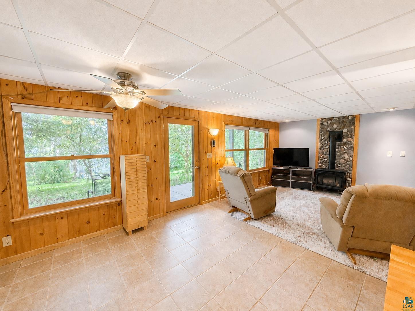 1787 North Bay Road Ely, MN 55731 - Photo 26 of 40 Living area featuring wood paneling, tile flooring, and a drop ceiling