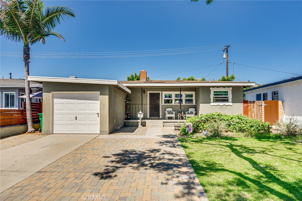 a front view of a house with a yard and potted plants