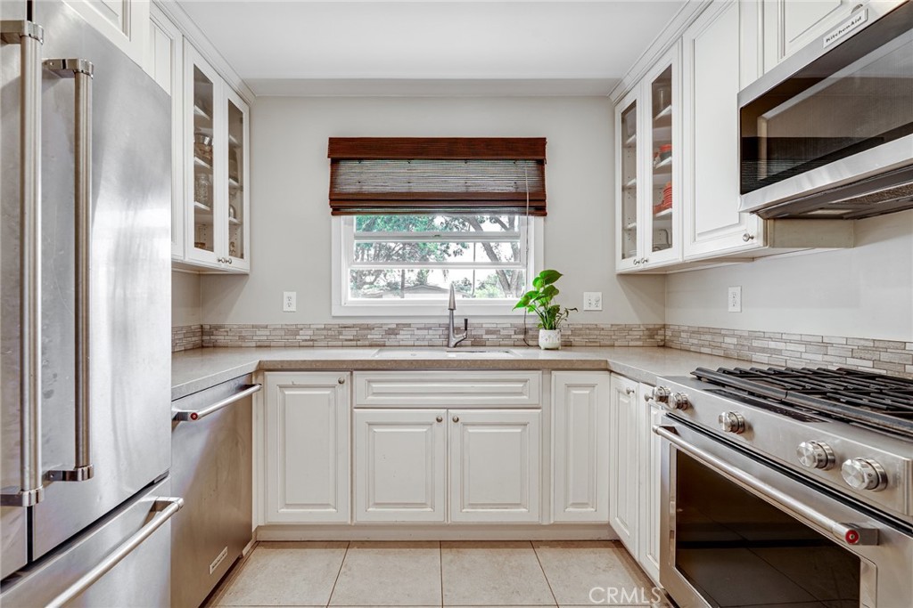 3513 Gondar Avenue Long Beach, CA 90808 - Photo 13 of 30 a kitchen with white cabinets and appliances