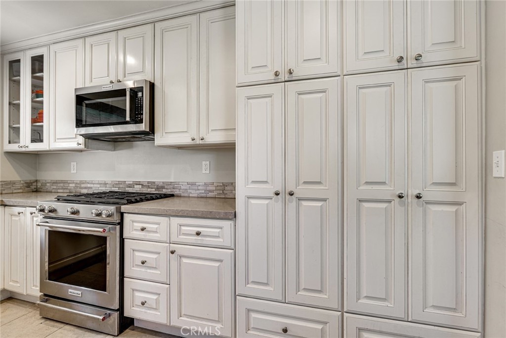 3513 Gondar Avenue Long Beach, CA 90808 - Photo 14 of 30 a kitchen with white cabinets and stainless steel appliances