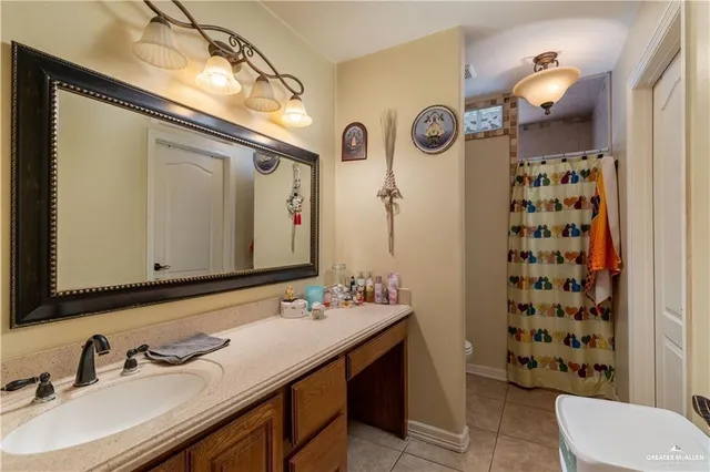 a bathroom with a sink a toilet and shower curtain