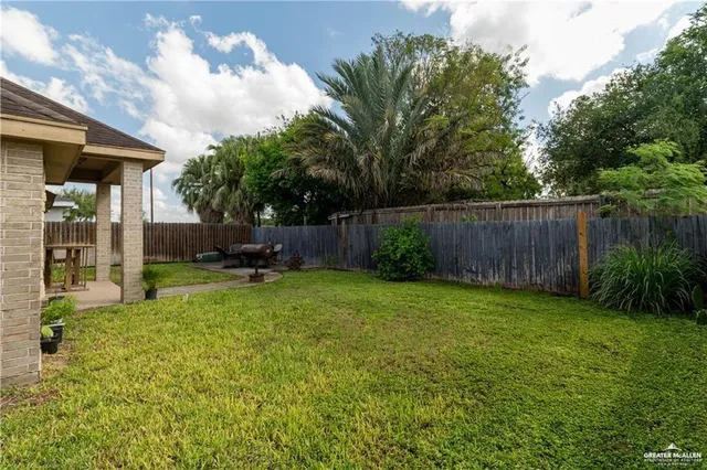 a view of a backyard with table and chairs and potted plants and large trees