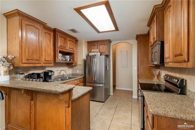 a kitchen with stainless steel appliances granite countertop a refrigerator and a stove top oven