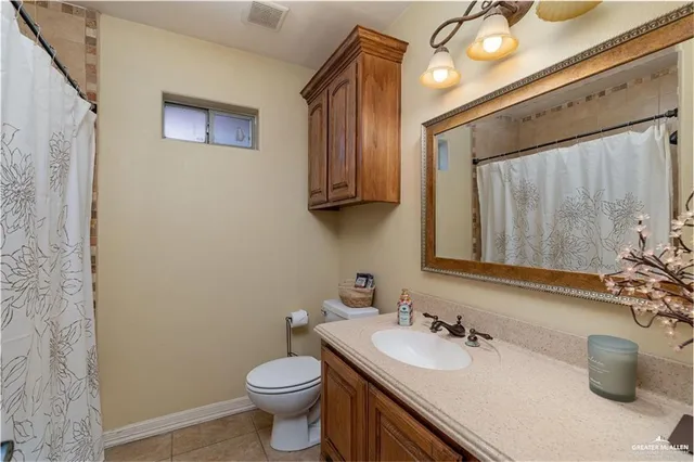 a bathroom with a sink vanity mirror and toilet