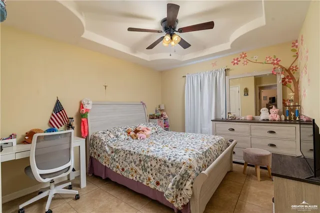 a bedroom with a bed dresser and a chandelier