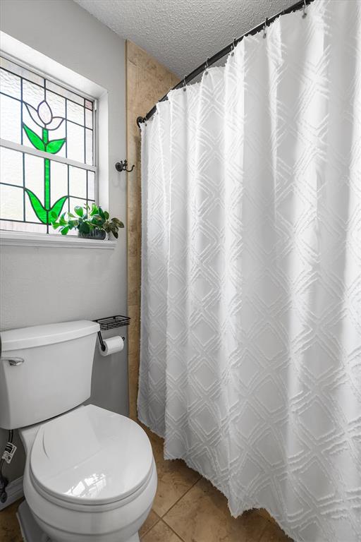 410 Simmons Road Double Oak, TX 75077 - Photo 29 of 40 Full bath with shower, tile surround, and a charming stained glass window that adds a unique touch of character.