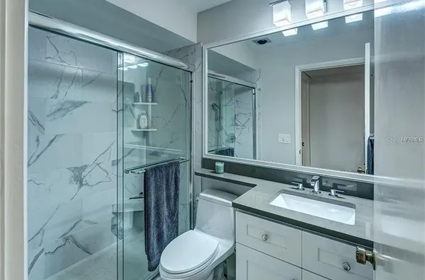 a bathroom with a sink a toilet and shower