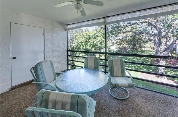 a view of a porch with furniture and a yard