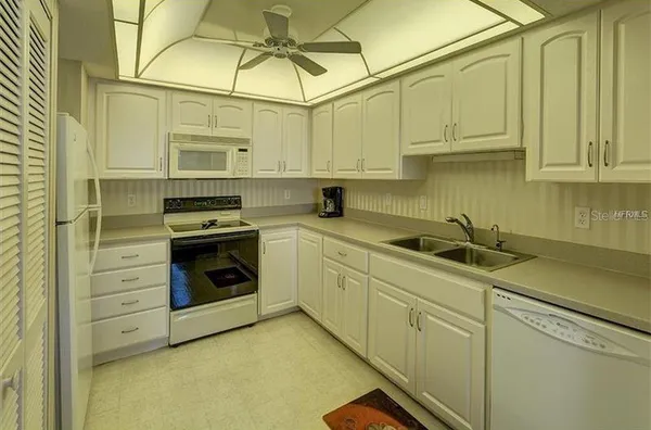 a kitchen with stainless steel appliances granite countertop a sink a stove and cabinets