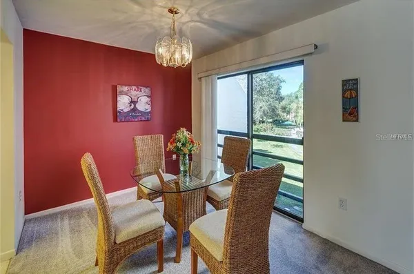 a dining room with furniture a rug and a chandelier