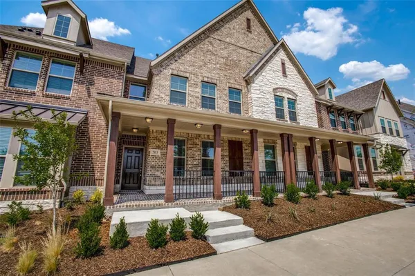 a view of a white house with large windows next to a yard