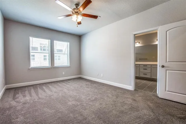 an empty room with a ceiling fan and wooden floor