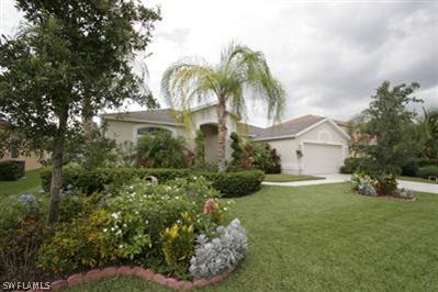 15057 Balmoral Loop Fort Myers, FL 33919 - Photo 1 of 10 a front view of a house with a yard and shrubs