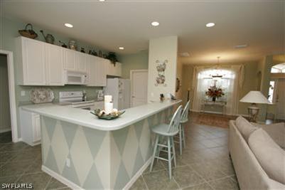 15057 Balmoral Loop Fort Myers, FL 33919 - Photo 3 of 10 a kitchen with stainless steel appliances kitchen island granite countertop a sink and cabinets